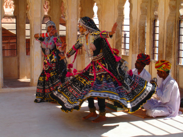 Ghoomar dancers twirling on stage with live music